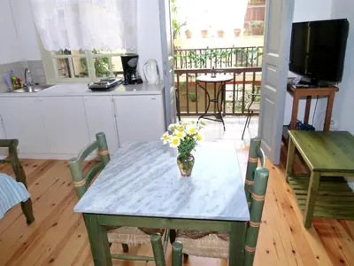 a kitchen with a table with a vase of flowers on it at Madonna Studios in Chania Town