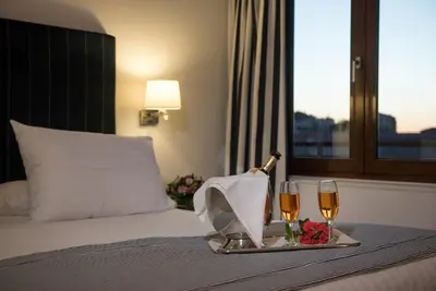 a hotel room with a bed with two glasses of champagne at Porto Veneziano Hotel in Chania Town