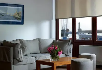 a living room with a couch and a table with flowers at Porto Veneziano Hotel in Chania Town