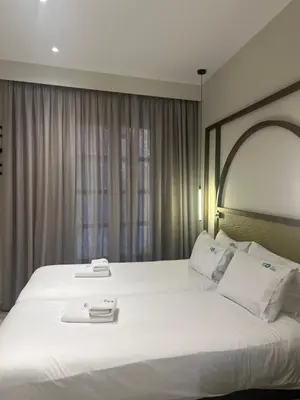 a hotel room with a large bed with two towels on it at El Greco Hotel in Chania Town