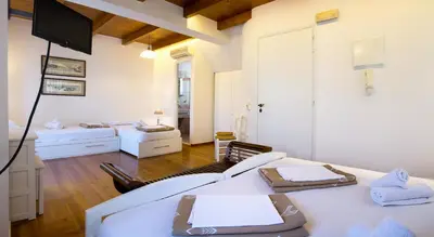 a living room with two beds and a flat screen tv at Ontas Traditional Hotel in Chania Town