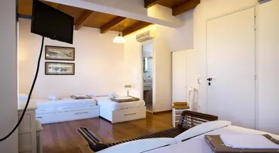 a living room with two beds and a flat screen tv at Ontas Traditional Hotel in Chania Town