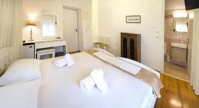 a bedroom with a large white bed with two pillows at Ontas Traditional Hotel in Chania Town