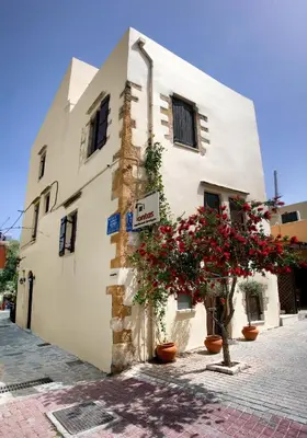 a white building with red flowers in front of it at Ontas Traditional Hotel in Chania Town