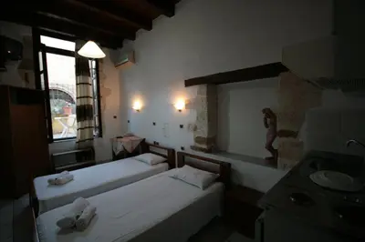 a room with two beds and a sink and a window at Chania Rooms in Chania Town
