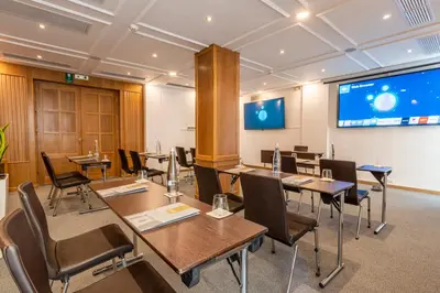 a conference room with tables and chairs and a projection screen at Kydon The Heart City Hotel in Chania Town