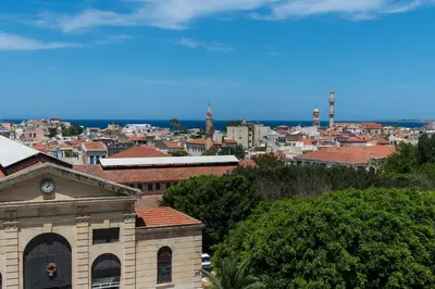 a view of a city with a clock on a building at Kydon The Heart City Hotel in Chania Town