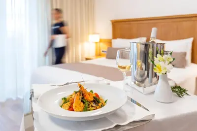 a table with a plate of food and a glass of wine at Kydon The Heart City Hotel in Chania Town