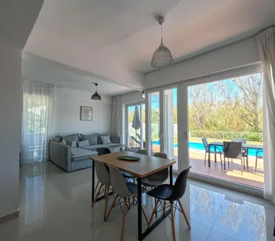 a living room with a table and chairs and a couch at Villa Meltemi in Daratso