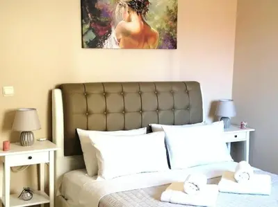 a bedroom with a bed with a painting above it at Odyseia Apts I at the center of the City & Old Town in Chania Town