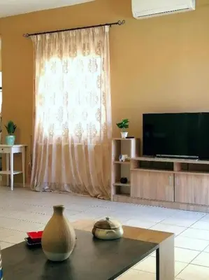 a living room with a vase on a table and a television at Odyseia Apts I at the center of the City & Old Town in Chania Town