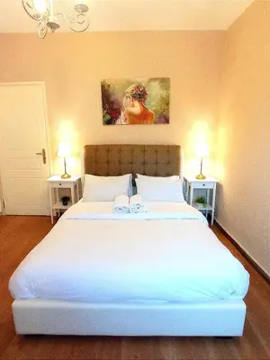 a bedroom with a large white bed with two lamps at Odyseia Apts I at the center of the City & Old Town in Chania Town