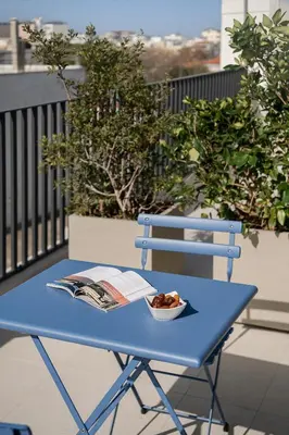 a blue table with a book and a bowl of nuts at Arkadi Hotel in Chania Town