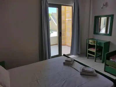 a bedroom with a bed and a large window at Viglia Beach Apartments in Kissamos