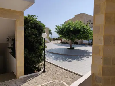 a courtyard with a tree and a building at Viglia Beach Apartments in Kissamos