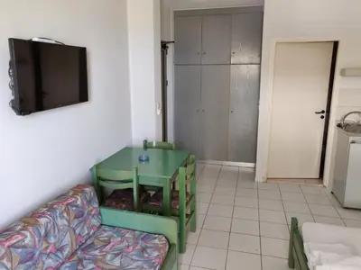 a living room with a couch and a tv at Viglia Beach Apartments in Kissamos