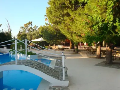 a swimming pool with a metal railing next to a tree at Monte Vardia in Chania Town