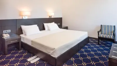 a bedroom with a large bed and a chair at Monte Vardia in Chania Town