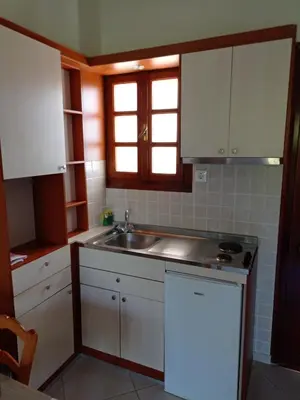 a kitchen with white cabinets and a sink at Alexandros Studios in Kalamaki Chanion