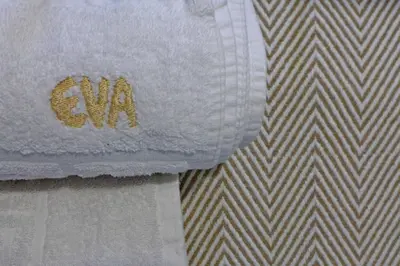 a towel with the word au on it sitting on a bed at Pension Eva in Chania Town