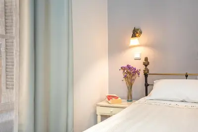 a bedroom with a bed and a vase of flowers on a table at Pension Eva in Chania Town