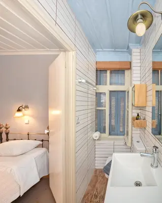 a bathroom with a bed and a sink in a room at Pension Eva in Chania Town