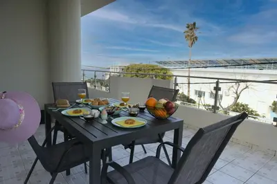 a table with a bowl of fruit and drinks on a balcony at Alsalos Sea View Apartment in Chania Town
