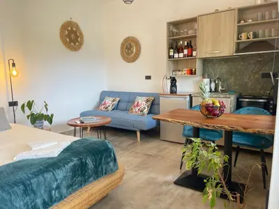 a living room with a blue couch and a table at Cavos Luxury Apartments in Kissamos