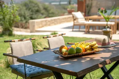 a picnic table with a bowl of fruit on it at Cavos Luxury Apartments in Kissamos