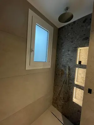 a bathroom with a shower and a window at Mediterranean Sea Top Floor in Palaiochóra