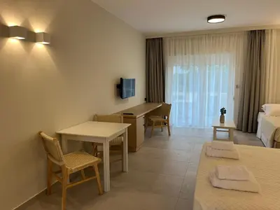 a hotel room with a bed and a table and chairs at Mediterranean Sea Top Floor in Palaiochóra