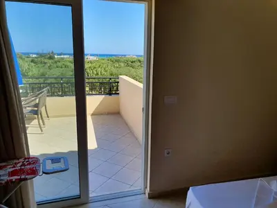 a door to a balcony with a view of the ocean at Selini Villas with private pool 10 minutes walking from the beach in Ropanianá