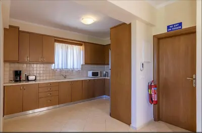 an empty kitchen with wooden cabinets and a door at Selini Villas with private pool 10 minutes walking from the beach in Ropanianá