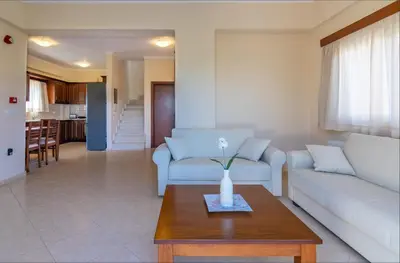 a living room with a couch and a table at Selini Villas with private pool 10 minutes walking from the beach in Ropanianá