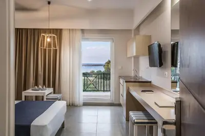 a hotel room with a bed and a view of the ocean at Sea View Hotel & Apartments in Kato Daratso