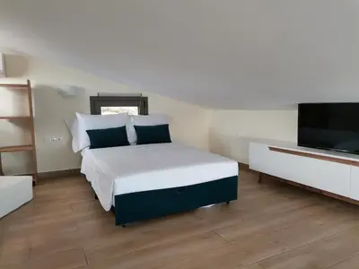 a bedroom with a bed and a flat screen tv at Olive and Aloe Villas in Nomikianá