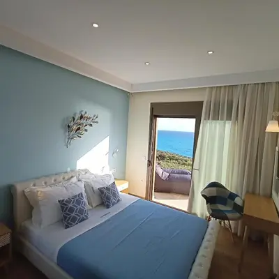 a bedroom with a bed and a view of the ocean at Olive and Aloe Villas in Nomikianá