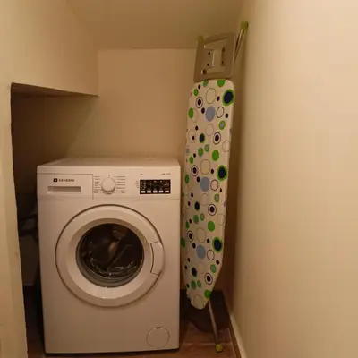 a laundry room with a washing machine next to a wall at Olive and Aloe Villas in Nomikianá