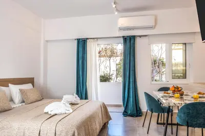 a bedroom with a bed and a table with chairs at Annet in Chania Town