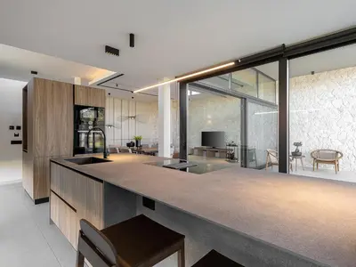 a kitchen with a counter and a living room at Pnoe Villas - Seafront Experience in Tavronitis