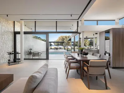 an open living room with a table and chairs at Pnoe Villas - Seafront Experience in Tavronitis
