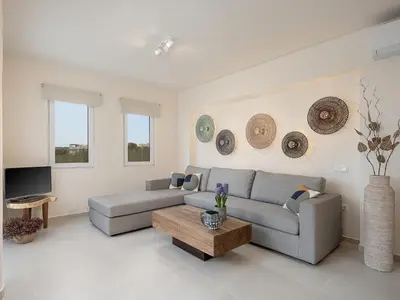 a living room with a couch and a coffee table at Calmaliving Seaside apartments with pool in Gerani Chanion