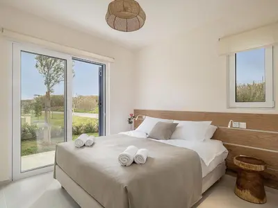 a bedroom with a large bed with two towels on it at Calmaliving Seaside apartments with pool in Gerani Chanion