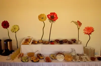 a table with flowers on top of a shelf with cookies at Kissamos Hotel in Kissamos