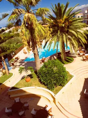 an aerial view of a resort with palm trees and a pool at Kissamos Hotel in Kissamos