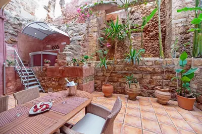 a patio with a table and chairs and plants at Casa Kasteli in Chania Town