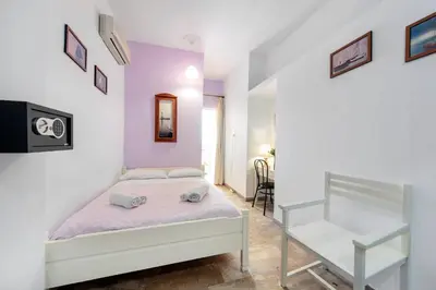 a white bedroom with a bed and a staircase at Casa Kasteli in Chania Town
