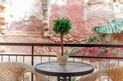 a table with a potted plant on a balcony at Casa Kasteli in Chania Town