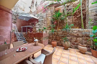 a patio with a table and chairs and plants at KasteliSuites in Chania Town