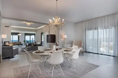 a dining room and living room with a table and chairs at Villa Pirgos Luxury in Kissamos